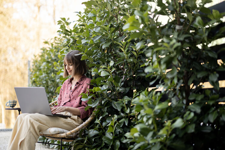 Dame arbeitet am Laptop im Grünen