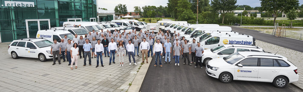 Gruppenbild Mitarbeitende und Fahrzeuge Elektro Hörtensteiner